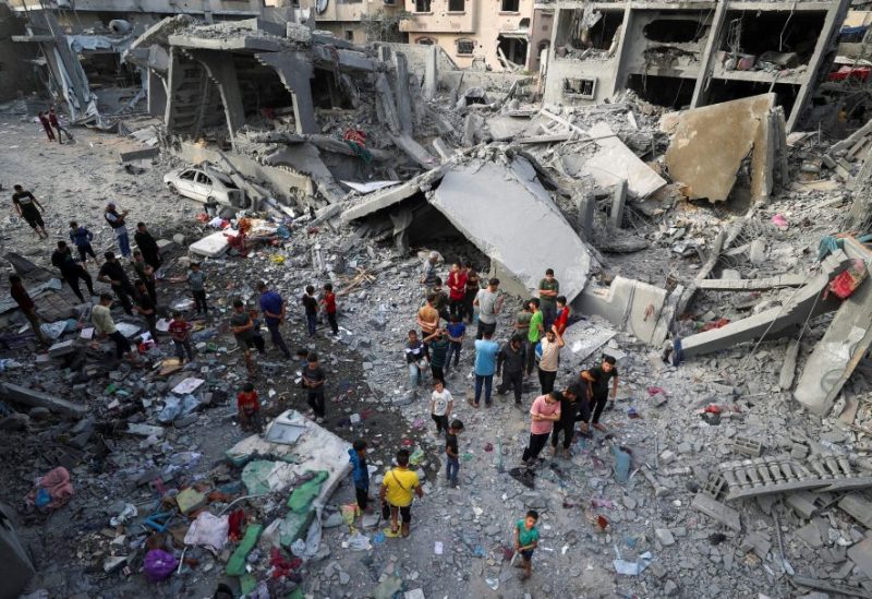 فلسطينيون يتفقدون موقع غارة إسرائيلية على منزل في جباليا، شمال قطاع غزة، 18 مايو/أيار 2025. رويترز