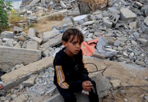 فتى فلسطيني يجلس على الأنقاض، بعد غارة إسرائيلية في خان يونس، جنوب قطاع غزة، 19 مايو/أيار 2025. رويترز