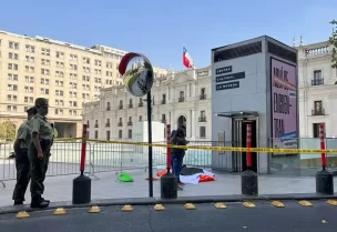 متظاهرون يقفون خارج قصر لا مونيدا الرئاسي خلال احتجاج في سانتياغو بتشيلي (رويترز)