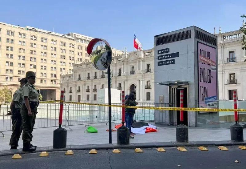 متظاهرون يقفون خارج قصر لا مونيدا الرئاسي خلال احتجاج في سانتياغو بتشيلي (رويترز)