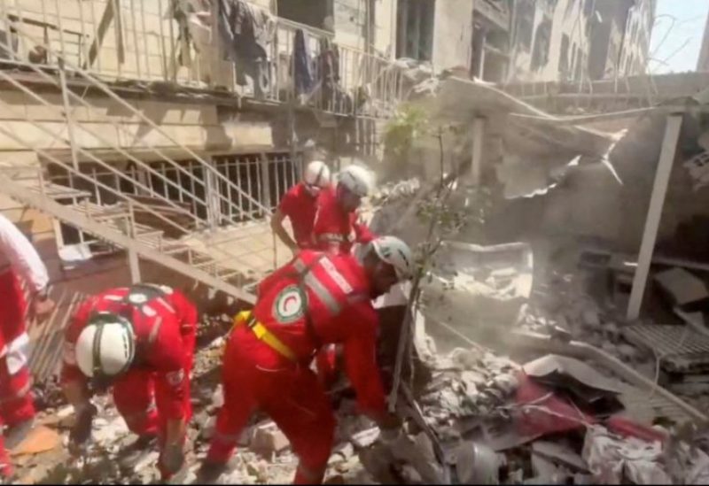 عمال الإنقاذ يعملون في موقع مبنى متضرر في أعقاب الغارات الإسرائيلية في طهران، إيران، 14 يونيو 2025. رويترز