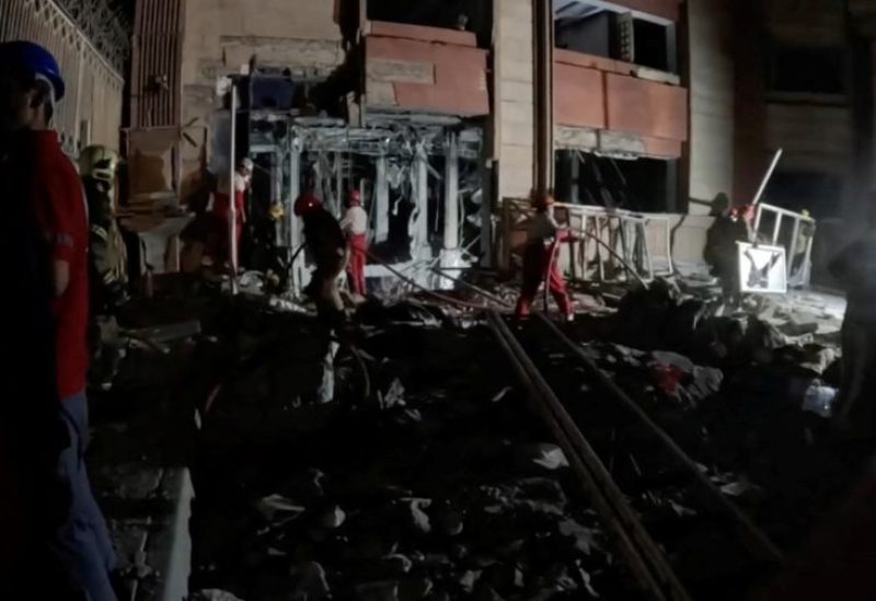 أعضاء من جمعية الهلال الأحمر الإيراني يعملون في موقع غارة إسرائيلية في طهران، إيران، 15 يونيو 2025. رويترز