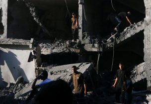 فلسطينيون يتفقدون موقع غارة جوية إسرائيلية على منزل في مدينة غزة، 27 يونيو/حزيران 2025. رويترز