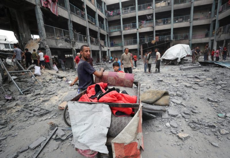 فلسطينيون يتفقدون الأضرار التي لحقت بمدرسة تابعة للأونروا تأوي نازحين تعرضت لغارة جوية إسرائيلية يوم الأحد في مدينة غزة، 30 يونيو/حزيران 2025. رويترز