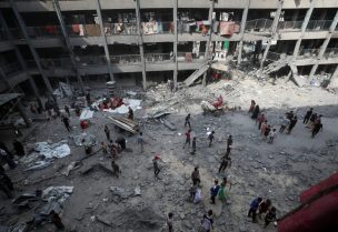 فلسطينيون يتفقدون الأضرار التي لحقت بمدرسة تابعة للأونروا تأوي نازحين تعرضت لغارة جوية إسرائيلية في مدينة غزة. رويترز