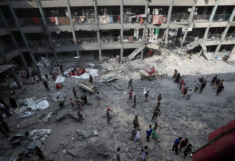 فلسطينيون يتفقدون الأضرار التي لحقت بمدرسة تابعة للأونروا تأوي نازحين تعرضت لغارة جوية إسرائيلية في مدينة غزة. رويترز