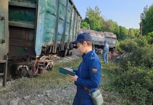 أخصائيون من خدمات الطوارئ يتجمعون بالقرب من عربة قطار مدمرة في مكان الحادث، بعد انهيار جسر على قضبان السكك الحديدية بسبب انفجار في منطقة بريانسك، روسيا، 1 يونيو/حزيران 2025. رويترز