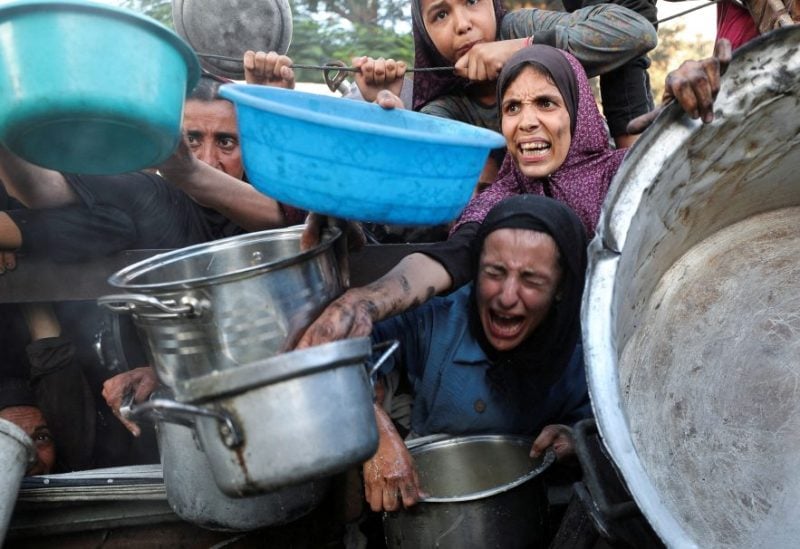 فلسطينيون ينتظرون الطعام من مطبخ خيري وسط أزمة الجوع في مدينة غزة، 14 يوليو/تموز 2025. رويترز