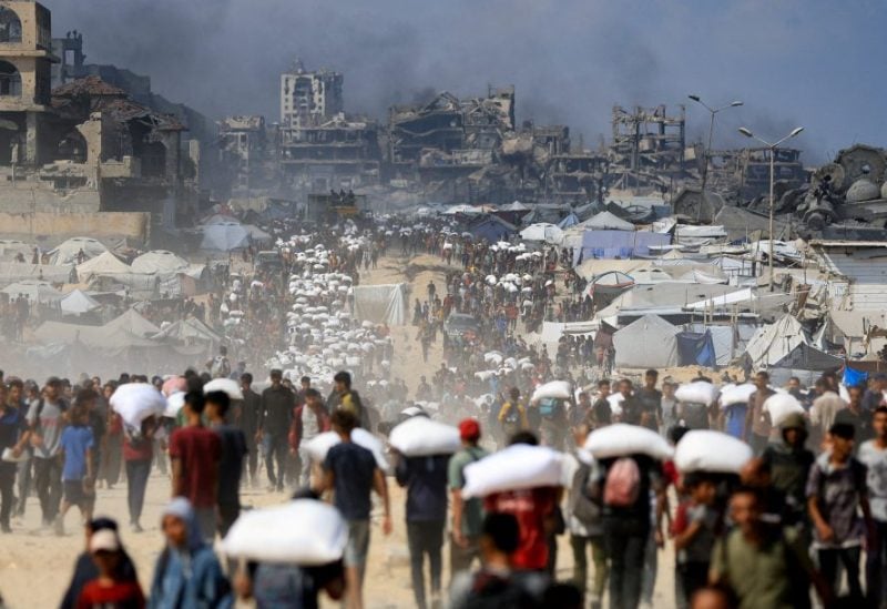فلسطينيون يتجمعون وهم يحملون إمدادات الإغاثة التي دخلت غزة عبر إسرائيل، وسط أزمة الجوع، في بيت لاهيا شمال قطاع غزة في 20 يوليو/تموز 2025. رويترز