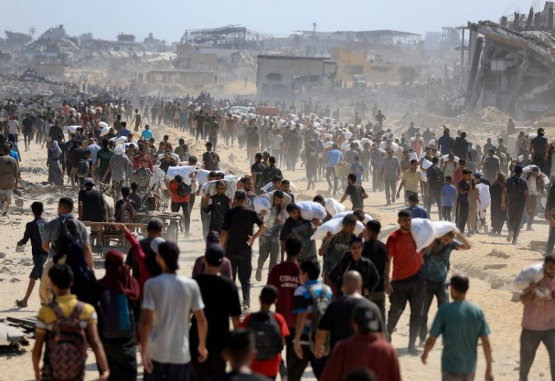 فلسطينيون يتجمعون وهم يحملون إمدادات الإغاثة التي دخلت غزة عبر إسرائيل، وسط أزمة الجوع، في بيت لاهيا شمال قطاع غزة في 20 يوليو/تموز 2025. رويترز