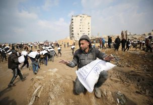فلسطينيون يحملون أكياس دقيق أخذوها من شاحنة مساعدات بالقرب من حاجز إسرائيلي، في ظل أزمة الجوع التي يواجهها سكان غزة، في مدينة غزة، 19 فبراير 2024. رويترز