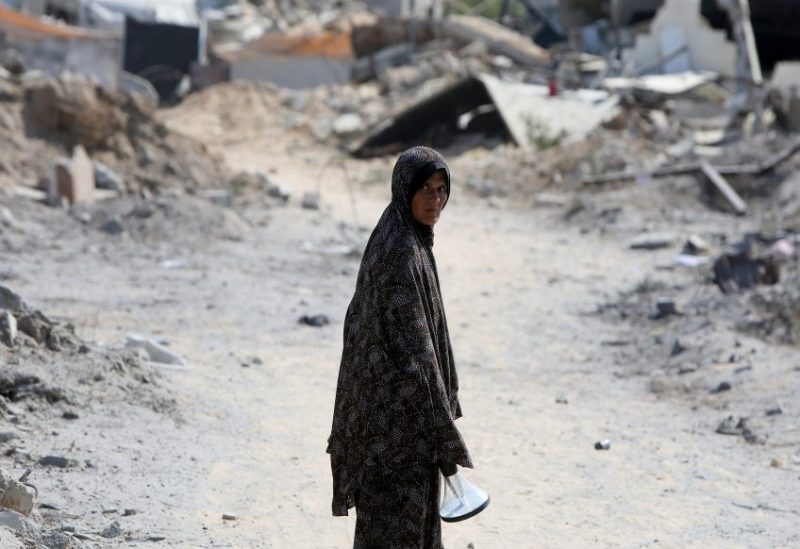 امرأة فلسطينية تنظر إلى موقع منازل دمرت خلال غارة إسرائيلية، في الجزء الغربي من النصيرات، وسط قطاع غزة، 29 يوليو 2025. رويترز