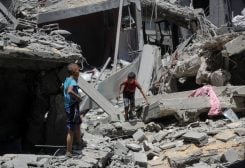 أطفال فلسطينيون يتفقدون موقع غارة إسرائيلية على منزل في مدينة غزة، 8 أغسطس 2025. رويترز