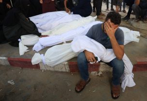 رجل يبكي على جثة طفل مغطاة بكفن خلال جنازة فلسطينيين استشهدوا في غارة جوية على خيمة خلال الليل، في مستشفى الشفاء بمدينة غزة، 29 أغسطس 2025. رويترز
