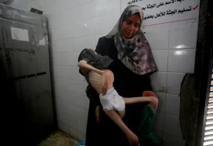 والدة تامر تحمل جثمانه في مستشفى شهداء الأقصى وسط قطاع غزة (الأناضول)