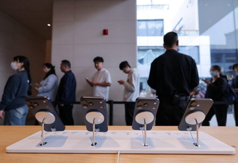الناس يصطفون بجانب الهواتف الذكية الجديدة من سلسلة iPhone 17 المعروضة داخل متجر Apple في منطقة سانليتون في بكين خلال بدء المبيعات في بكين، الصين، 19 سبتمبر 2025. رويترز