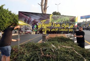 مناصرون لحزب الله يحملون لافتة ترفض تسليم السلاح للجيش اللبناني