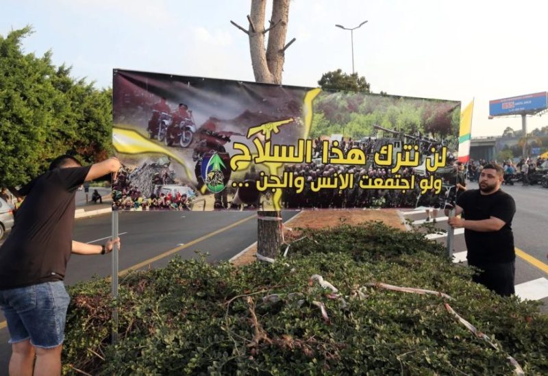 مناصرون لحزب الله يحملون لافتة ترفض تسليم السلاح للجيش اللبناني
