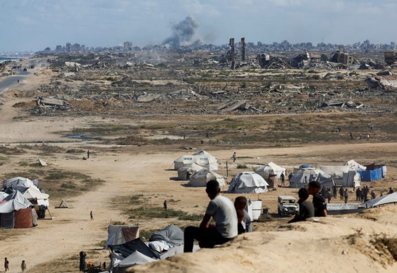 فلسطينيون يشاهدون الدخان يتصاعد عقب غارات إسرائيلية على مدينة غزة، في 5 أكتوبر 2025. رويترز