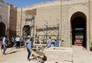 عمال يرممون أجزاء من مدينة بابل القديمة تضررت بسبب تتغير المناخ في العراق