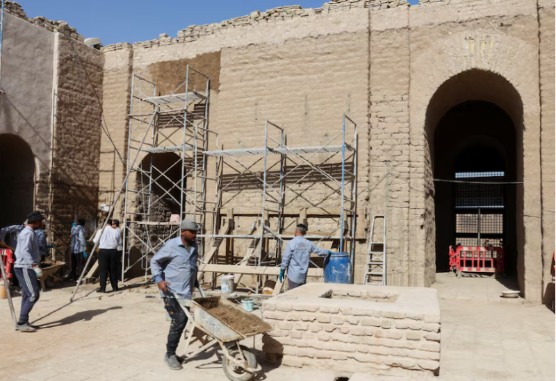 عمال يرممون أجزاء من مدينة بابل القديمة تضررت بسبب تتغير المناخ في العراق