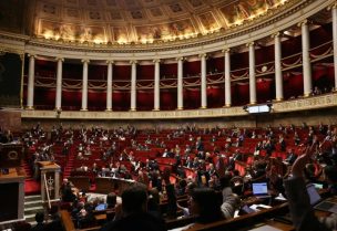 أعضاء البرلمان يرفعون أيديهم خلال جلسة مناقشة مشروع قانون الموازنة لعام 2026 في الجمعية الوطنية (أ.ف.ب)