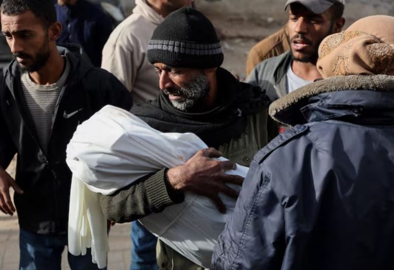 أحد المشيعين يحمل جثمانا خلال جنازة فلسطينيين قُتلوا جراء غارات إسرائيلية في غزة