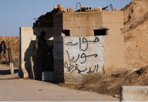 أحد أفراد الجيش السوري يقف عند مدخل سجن الشدادي عقب انسحاب قوات سوريا الديمقراطية وسيطرة الجيش السوري عليه - رويترز