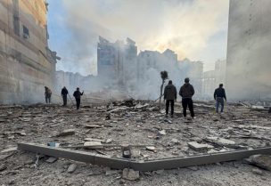 أشخاص يقفون على أنقاض مبنى مدمر بعد غارة إسرائيلية على الضاحية الجنوبية لبيروت. رويترز