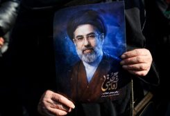 امرأة تحمل صورة للمرشد الإيراني مجتبى خامنئي خلال تجمع في طهران