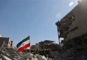 علم إيران يرفرف فوق الحطام عقب غارة إسرائيلية وأمريكية على مركز للشرطة في طهران يوم 3 مارس آذار 2026. صورة من وكالة أنباء غرب آسيا (وانا) حصلت عليها رويترز من طرف ثالث