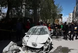 أشخاص يتجمعون بالقرب من سيارة متضررة في موقع مبنى سكني تضرر جراء غارة في خضم النزاع الأمريكي الإسرائيلي مع إيران في طهران يوم الجمعة. صورة من وكالة أنباء غرب آسيا (وانا) حصلت عليها رويترز من طرف ثالث.