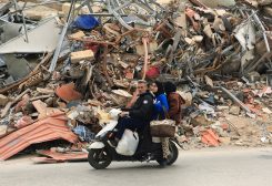 مواطنون أمام مبنى متضرر، بعد دخول وقف إطلاق النار المبرم بين لبنان وإسرائيل حيز التنفيذ لمدة 10 أيام، في الضاحية الجنوبية لبيروت.