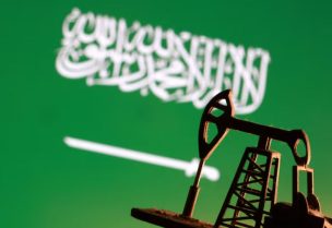 نموذج لرافعة مضخة نفط أمام علم السعودية - رويترز