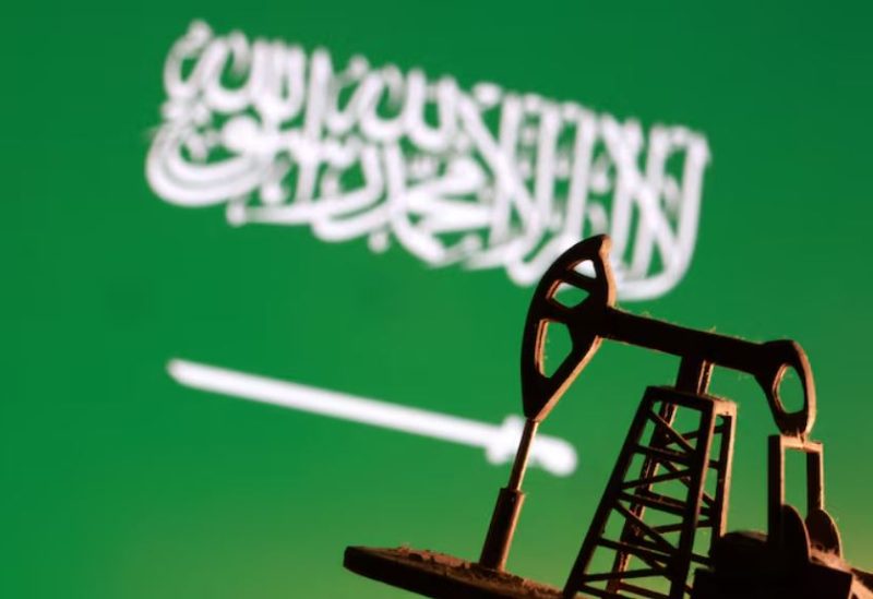 نموذج لرافعة مضخة نفط أمام علم السعودية - رويترز