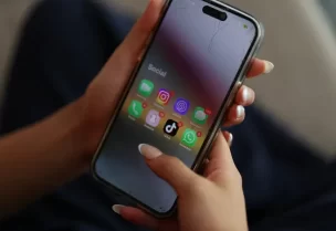 مراهقة تستخدم هاتًفا ذكيًا تظهر عل شاشته بعض تطبيقات التواصل الاجتماعي (رويترز)