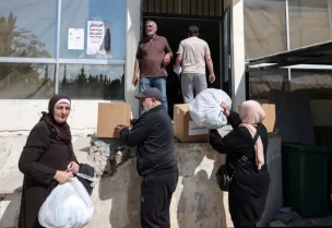 أشخاص يتلقون طرودا غذائية ومساعدات أخرى في مركز البلدية في صور بجنوب لبنان يوم 11 أبريل نيسان 2026. تصوير: لويزا جولياماكي - رويترز