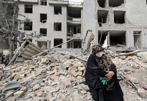 سيدة تجلس خارج منزلها المدمر جراء غارة جوية في طهران يوم 12 مارس آذار 2026. تصوير: علاء المرجاني – رويترز