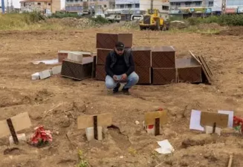 حسين صالح يعرض صورة ابنته بجوار قبرها في صور بلبنان يوم 7 أبريل نيسان 2026. تصوير: عدنان العبيدي - رويترز