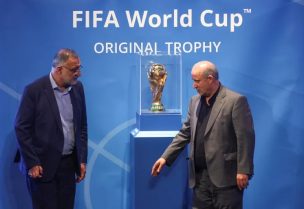 رئيس الاتحاد الإيراني لكرة القدم مهدي تاج بجوار مجسم كأس العالم