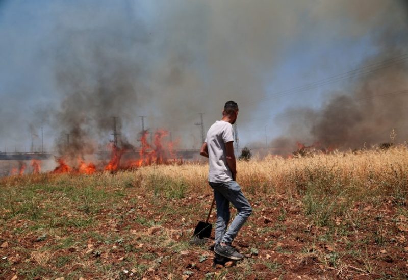 يسارع الفلسطينيون لإخماد حريق شب في حقل أشعله مستوطنون إسرائيليون، في بلدة حوارة بالقرب من نابلس، في الضفة الغربية. رويترز