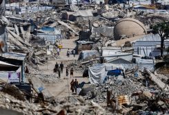 فلسطينيون يمرون أمام أنقاض مبانٍ سكنية دمرت خلال الحرب، في مخيم جباليا للاجئين شمال قطاع غزة، 12 يونيو 2026. رويترز