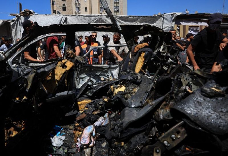 فلسطينيون يتفقدون مركبة أصيبت في غارة إسرائيلية، في مدينة غزة، 18 يونيو 2026. رويترز