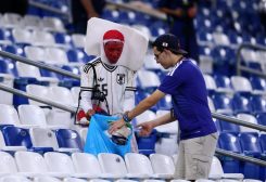 مشجعو اليابان ينظفون القمامة من مدرجات الملعب بعد المباراة ضد تونس (رويترز)