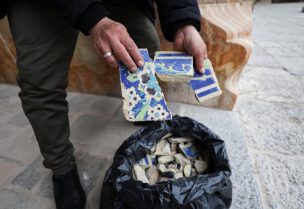 شخص يحمل شظايا من البلاط الزخرفي المكسور في مسجد الشاه الواقع على الطرف الجنوبي لميدان نقش جهان في أصفهان يوم 23 مارس آذار 2026. تصوير: علاء المرجاني - رويترز (تعمل وسائل الإعلام الأجنبية في إيران وفقا للمبادئ التوجيهية التي تضعها وزارة الثقافة والإرشاد الإسلامي، التي تنظم النشاط الصحفي وتمنح التراخيص.)