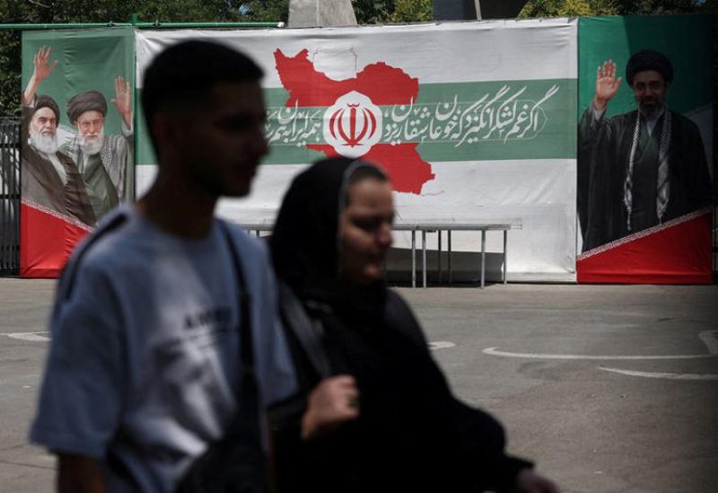 رجل وامرأة يمران أمام لافتة عليها صور الزعيم الراحل للثورة الإسلامية آية الله روح الله الخميني، والزعيم الأعلى لإيران آية الله علي خامنئي، والزعيم الأعلى الحالي مجتبى خامنئي، في أحد شوارع طهران يوم 9 يونيو حزيران 2026. صورة من وكالة أنباء غرب آسيا حصلت عليها رويترز من طرف ثالث. (يُحظر نشر الصورة في إسرائيل. ويُحظر بيع الصورة للأغراض التجارية أو التحريرية في إسرائيل. كما يُحظر حصول وسائل الإعلام الإسرائيلية على الصورة. يُحظر على بي.بي.سي الفارسية وفي.أو.إيه الفارسية ومانوتو وإيران الدولية وراديو فاردا استخدام الصورة. كما يُحظر على بي.بي.سي الفارسية وفي.أو.إيه الفارسية ومانوتو وإيران الدولية وراديو فاردا استخدام الصورة رقميا.)