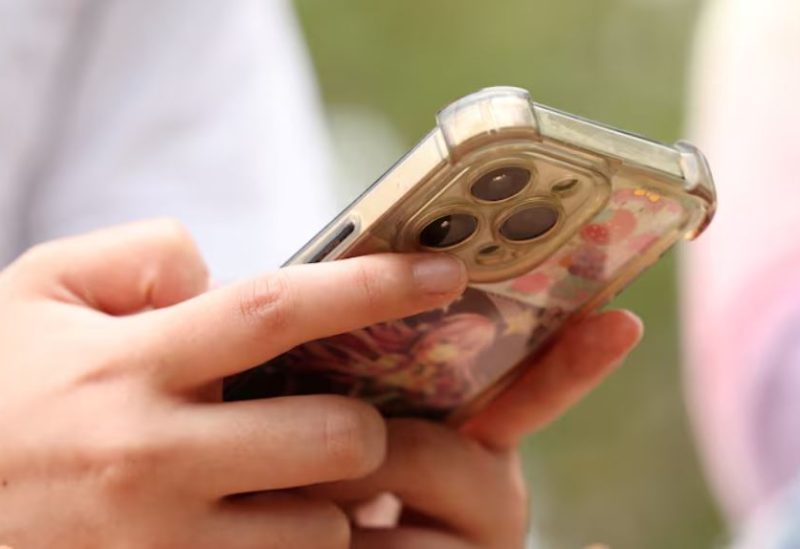 فتاة تستخدم هاتفها المحمول