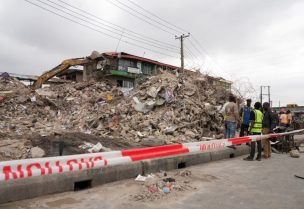 أشخاص يقفون بجانب أنقاض مبنى انهار في لاغوس بنيجيريا يوم 26 يونيو حزيران 2026. رويترز