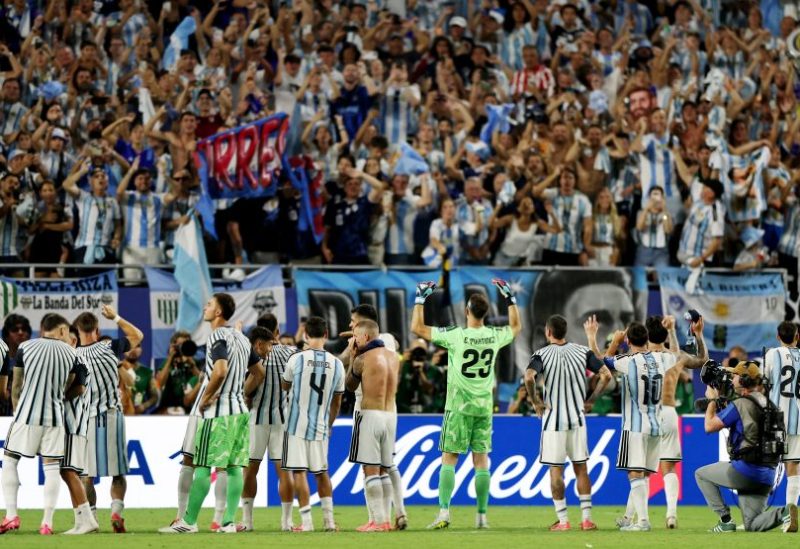 لاعبو الأرجنتين ومشجعوها يحتفلون بعد المباراة عقب تأهل الأرجنتين إلى دور الـ16 في كأس العالم. رويترز