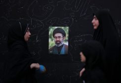 نساء يقفن أمام صورة المرشد الأعلى الإيراني مجتبى خامنئي